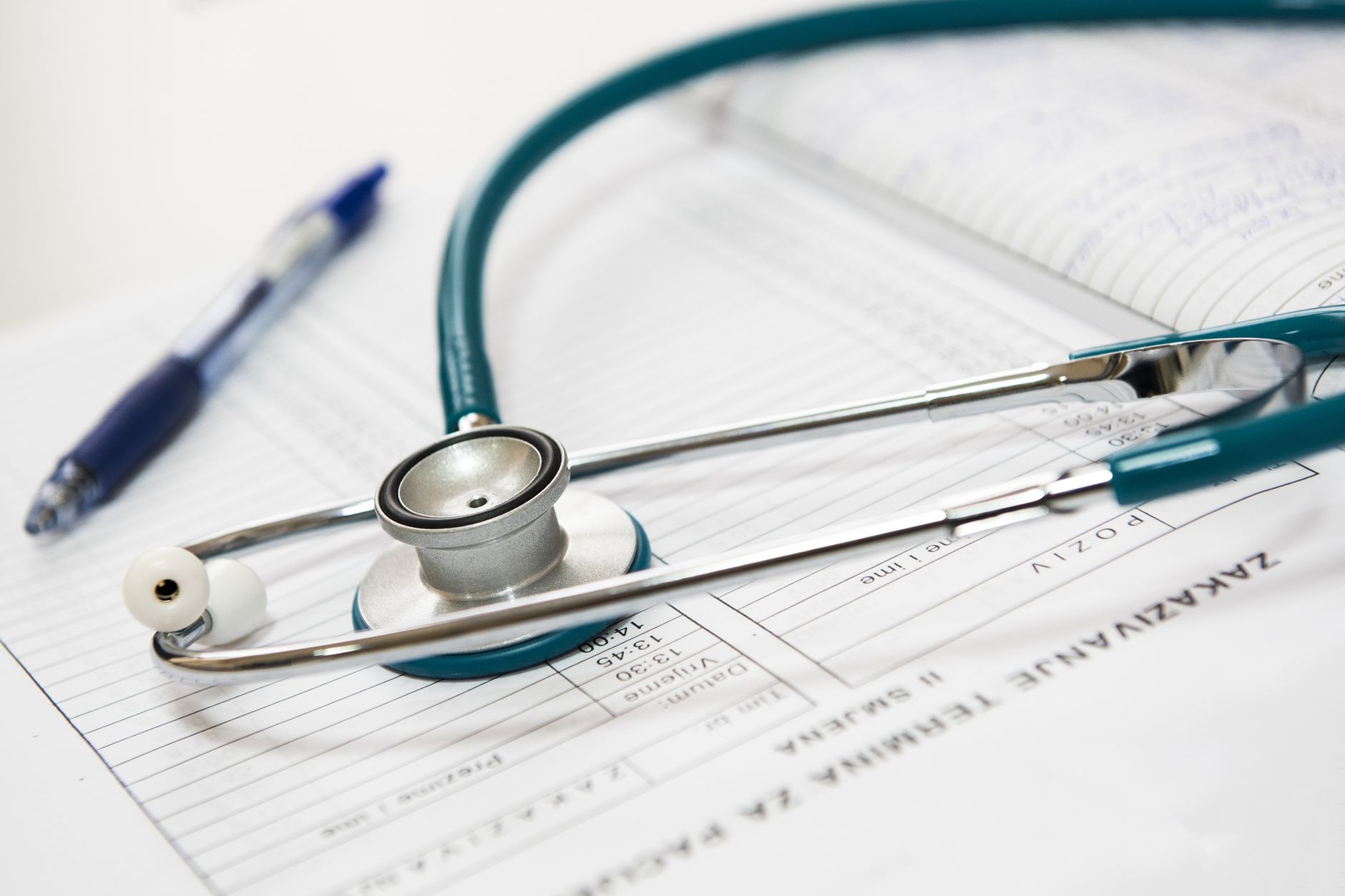 Laudo médico, exame de audiometria e estetoscópio sobre a mesa, representando a prova da deficiência e a avaliação médica e funcional exigida pela Lei Complementar 142/2013