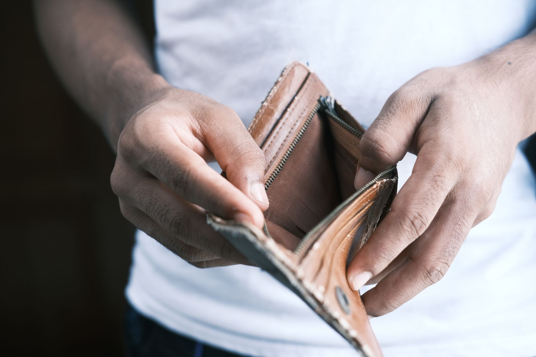 Calculadora, comprovantes de renda familiar e nota de salário mínimo sobre a mesa, representando o cálculo da renda per capita de um quarto do salário mínimo exigida para o BPC/LOAS