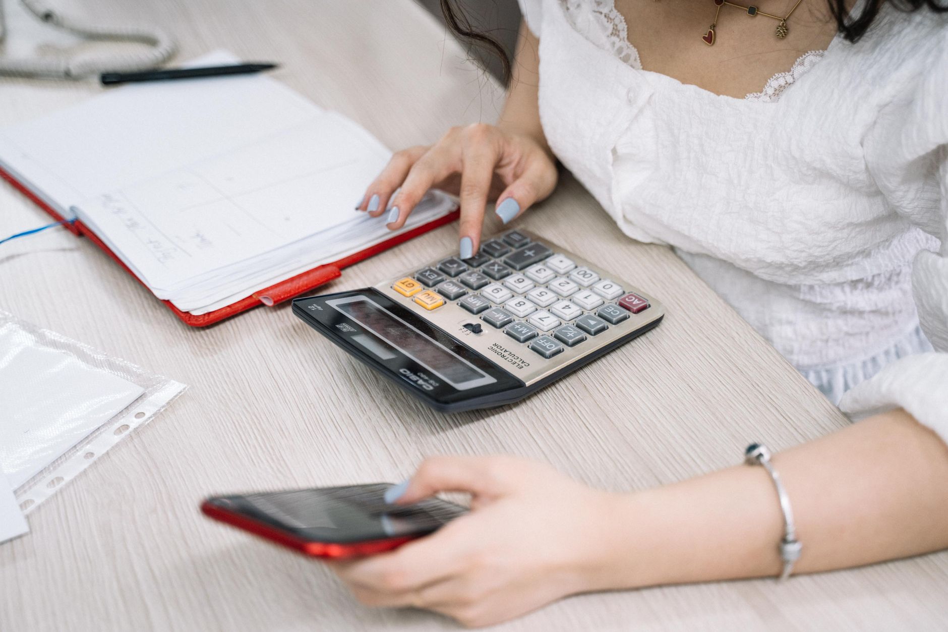 Cartão de ponto impresso sobre bancada metálica fria ao lado de uma calculadora, representando o cálculo do tempo de pausa suprimido e do pagamento devido pela não concessão do intervalo do art. 253 da CLT