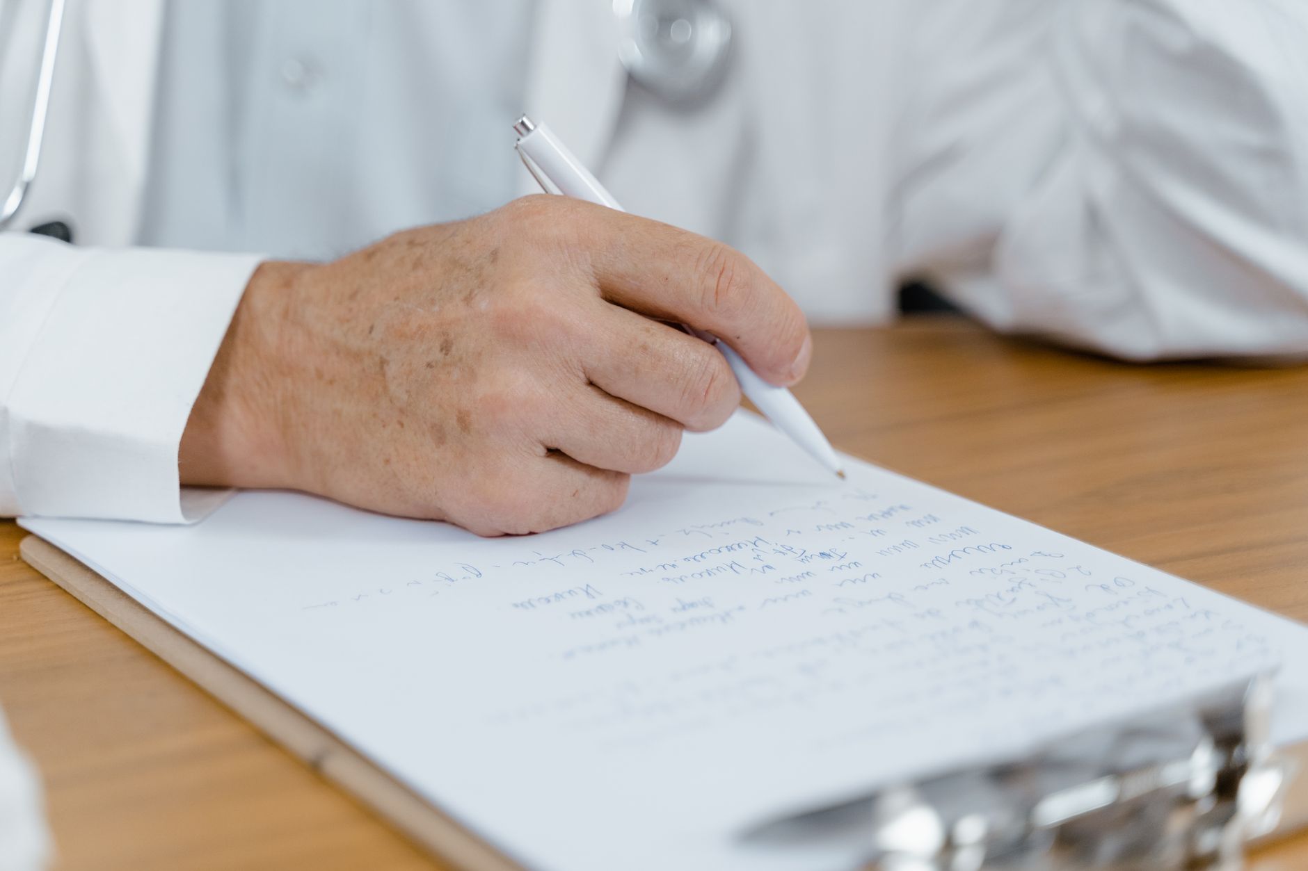 Formulário de Comunicação de Acidente de Trabalho e um laudo médico sobre mesa de aço, ao lado de um cartão de benefício, representando os pressupostos da estabilidade acidentária e a prova do nexo com o trabalho