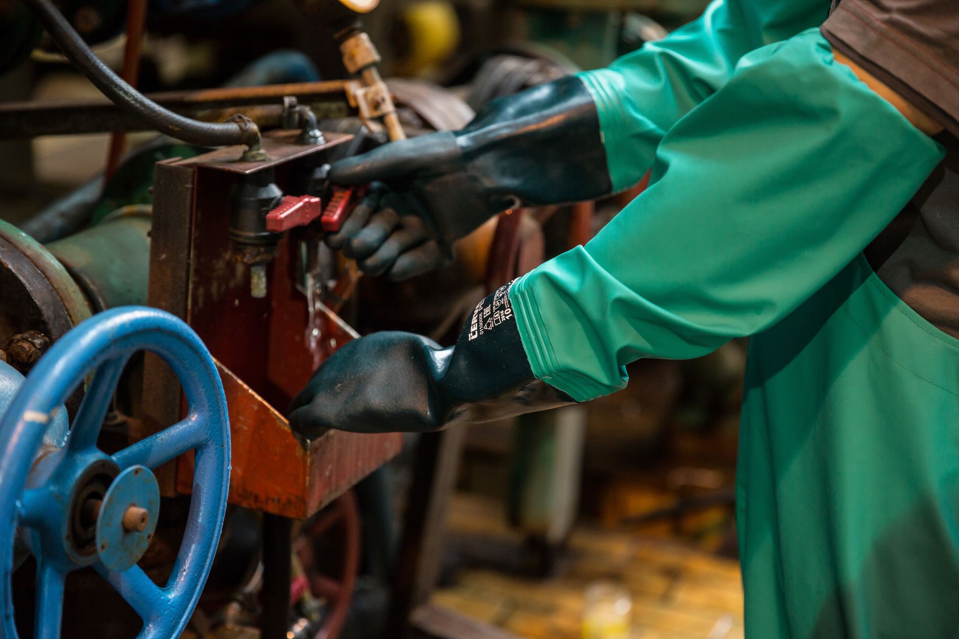 Luva térmica de proteção e uma faca de desossa pousadas sobre bancada de aço industrial gelada, ao lado de um formulário de comunicação de acidente de trabalho, símbolo da estabilidade acidentária do trabalhador de frigorífico