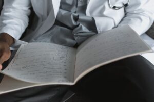 Dois peritos de jaleco analisam um documento medico, com estetoscopio, simbolizando a analise dos laudos do segurado