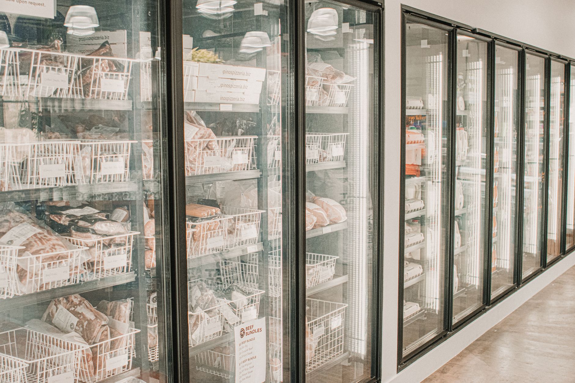 Câmara fria de frigorífico com carnes refrigeradas em expositores, foto do ambiente, sem pessoas.