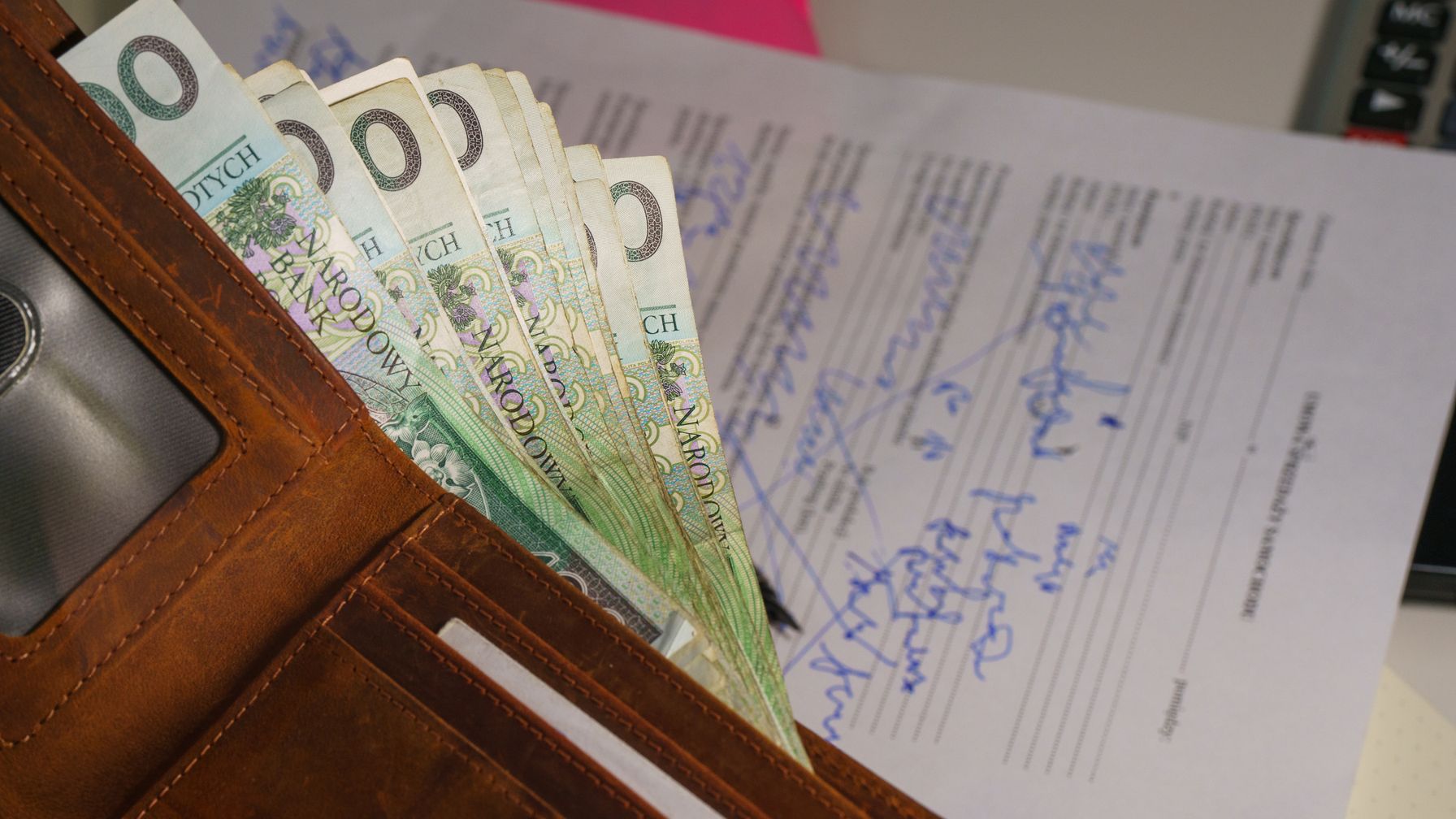 Comprovante de depósito bancário e recibo de pagamento sobre mesa de escritório; ilustra os dois meios de prova do pagamento previstos no art. 464 da CLT, o recibo assinado e o comprovante de depósito