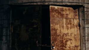 Cadeado fechado em porta metálica de instalação industrial, ilustrando o controle físico do acesso ao banheiro descrito nos processos examinados no artigo.