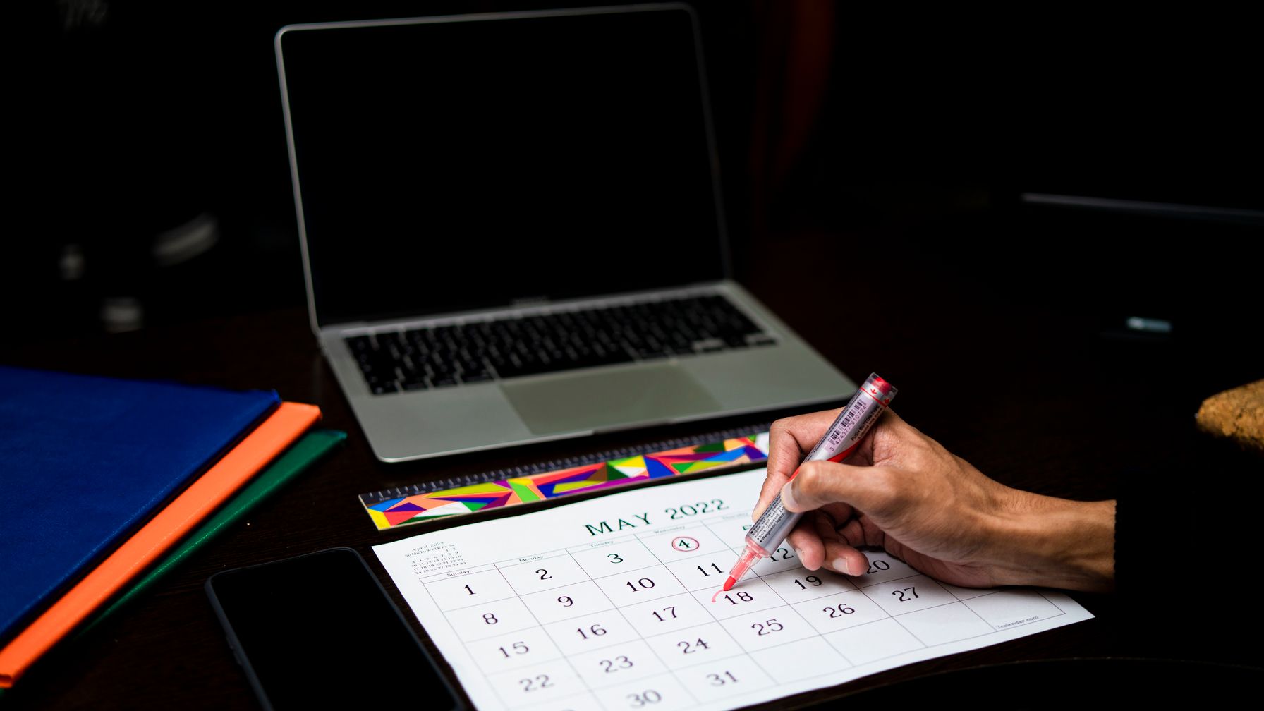 Calendário de mesa com caneta marcando uma data, ao lado de calculadora e contracheque; ilustra o cálculo das horas extras com adicional e reflexos e o prazo de dois anos após a saída