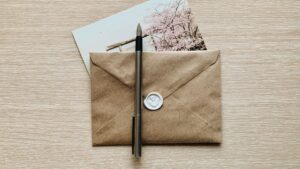 Envelope pardo lacrado com caneta sobre a mesa, ilustrando a carta de concessão do INSS que reconhece o benefício sem comprovar o crédito na conta